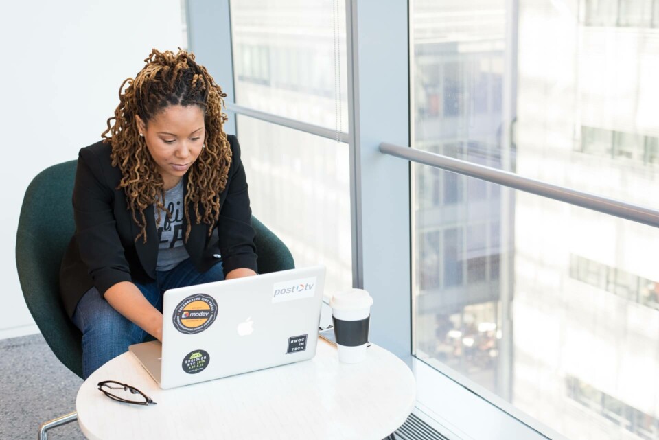 Mulher negra digitando em um notebook