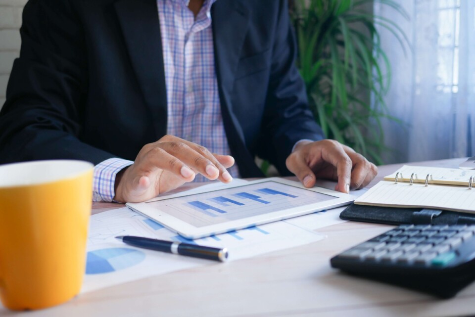 Homem da equipe de Financeiro mexe em tablet com dados