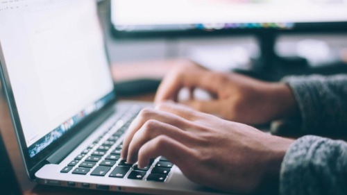 hands typing on computer keyboard