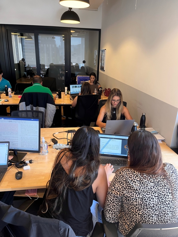 Foto mostra funcionários da Rooftop trabalhando no escritório em seus computadores