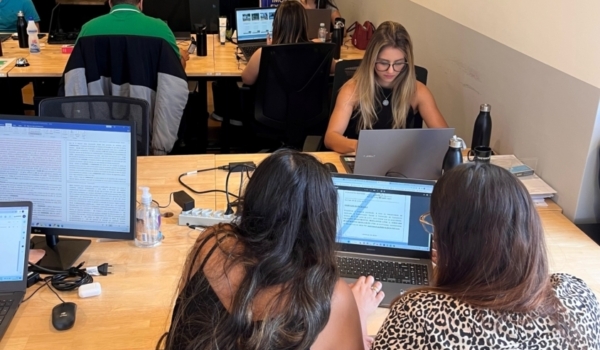 Foto mostra funcionários da Rooftop trabalhando no escritório em seus computadores