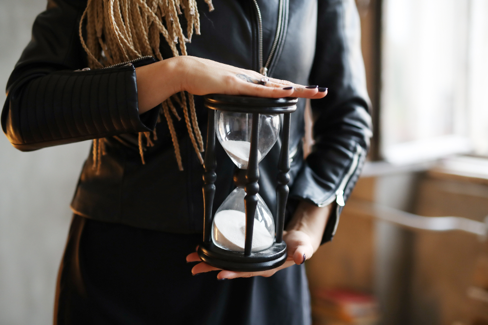 A woman holding an hourglass in a meeting room