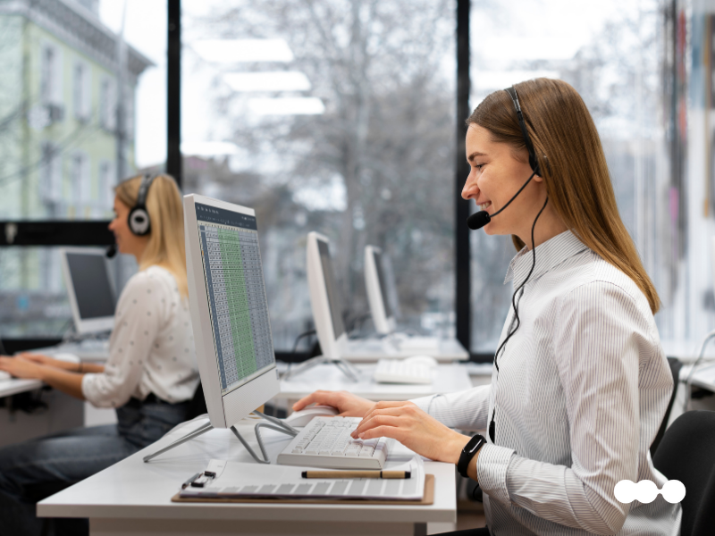 Customer service agent at her desk using a computer with a headset, representing speed in support delivery