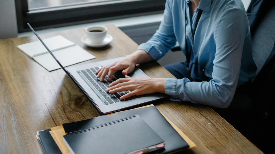 Profissional acessando portal corporativo em notebook, com interface intuitiva e foco em tarefas de RH e TI