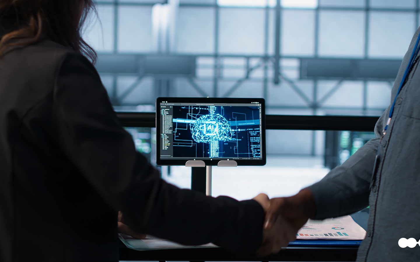 Profissionais cumprimentando-se em frente a tela com imagem de cérebro digital, simbolizando a atuação de agentes de IA no jurídico com segurança e automação