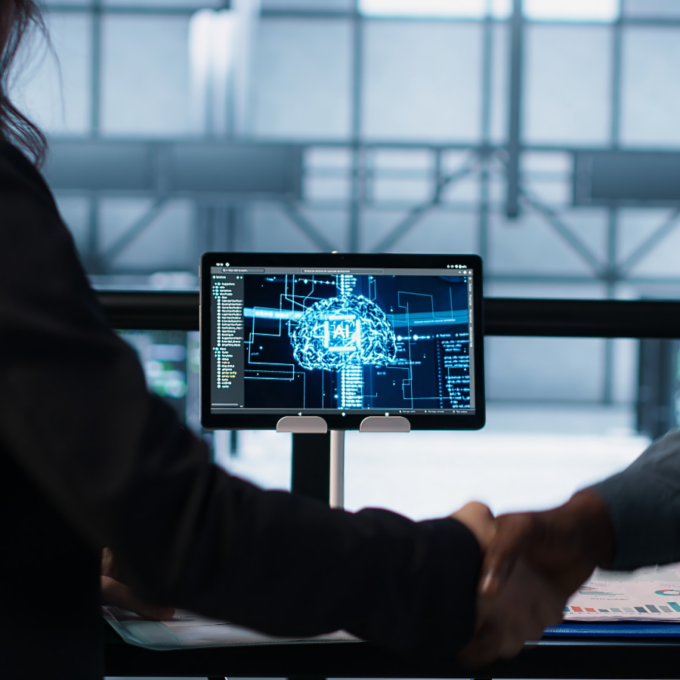 Profissionais cumprimentando-se em frente a tela com imagem de cérebro digital, simbolizando a atuação de agentes de IA no jurídico com segurança e automação
