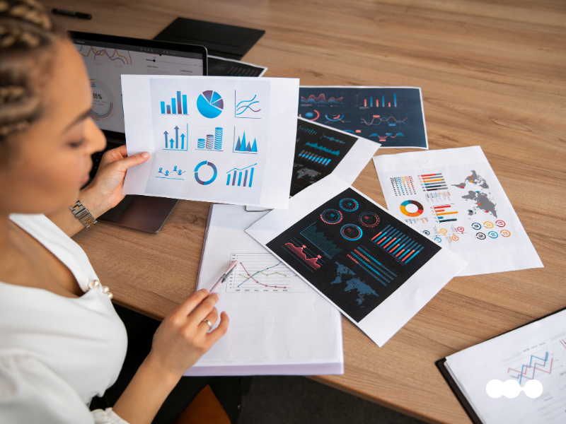 Professional reviewing dashboards and spreadsheets to compare financial reports
