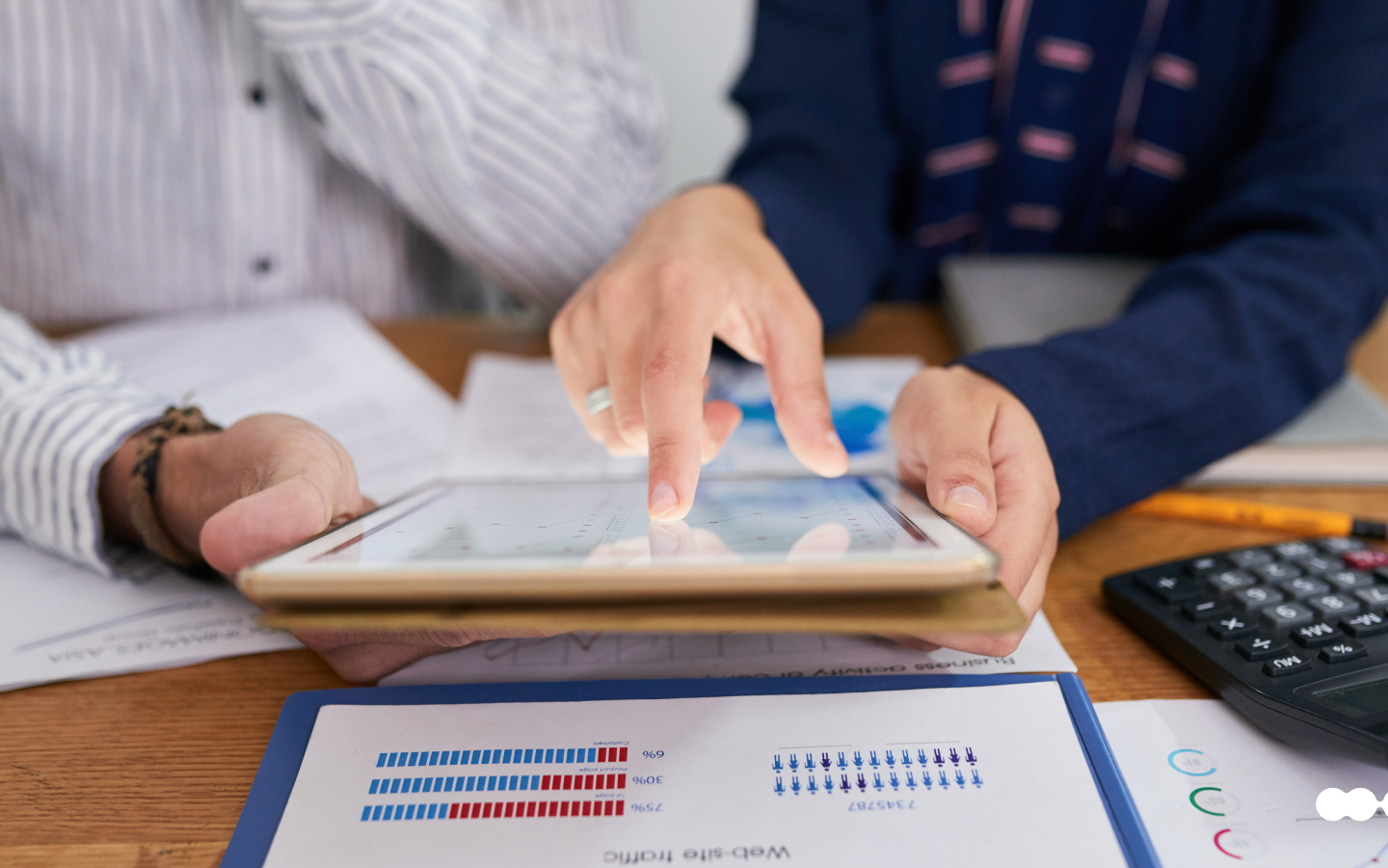 Professionals reviewing procure-to-pay performance data on a tablet and printed reports