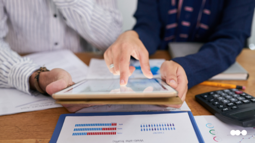 Professionals reviewing procure-to-pay performance data on a tablet and printed reports