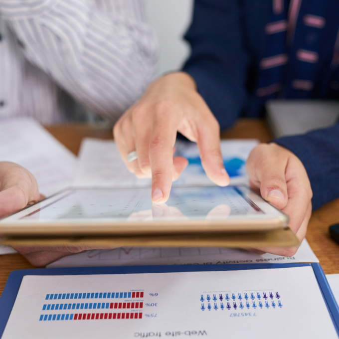 Professionals reviewing procure-to-pay performance data on a tablet and printed reports