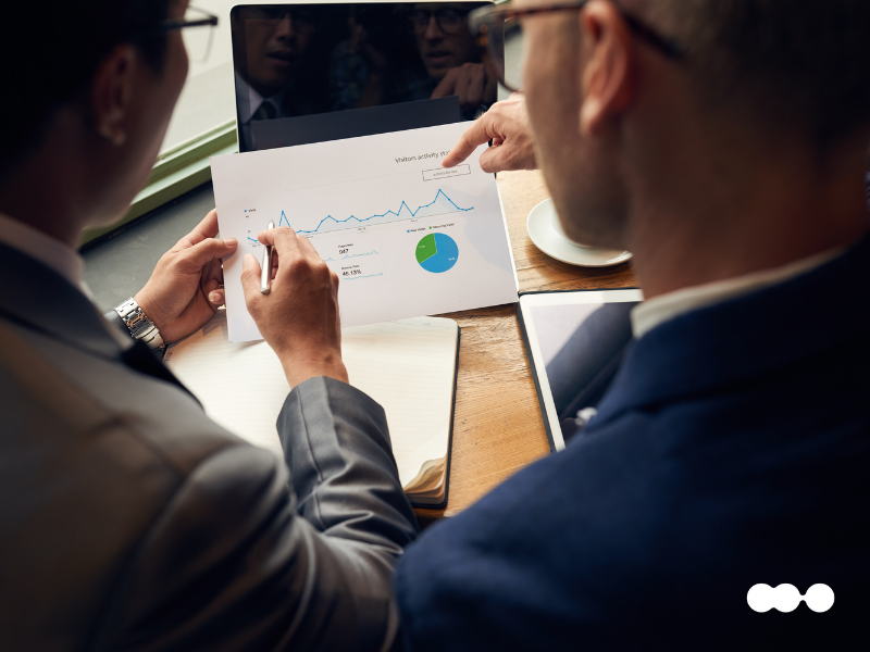 Two professionals analyzing financial data with charts during a reporting review