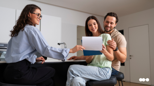 Couple reviewing lease documents with a property manager during the tenant onboarding process