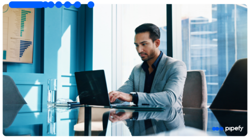 Profissional analisa dados da automação de crédito na operação B2B no seu laptop em um escritório corporativo