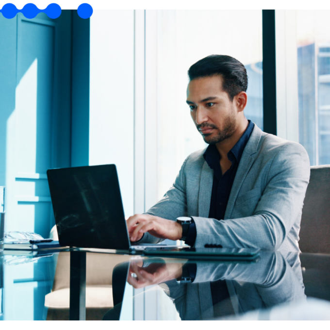 Profissional analisa dados da automação de crédito na operação B2B no seu laptop em um escritório corporativo
