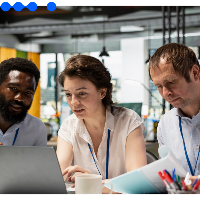 Equipe analisa dados em laptop e documentos em ambiente corporativo, representando a automação inteligente de processos com AI Workers em fluxos operacionais