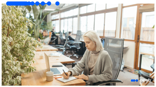 Profissional trabalhando em laptop e registrando anotações, representando processos de KYC pessoa física com automação e inteligência artificial