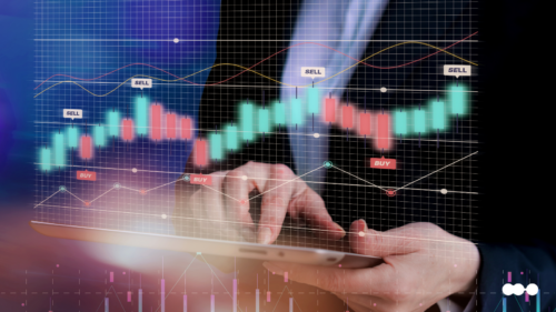 Financial services trends illustrated by a digital candlestick chart with buy and sell signals, over a businessperson using a tablet