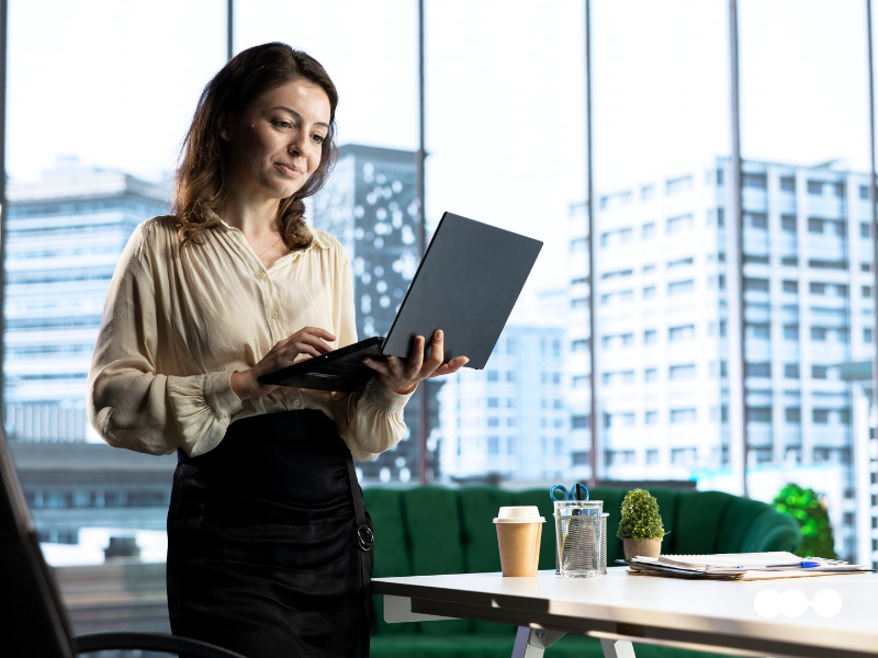 Businesswoman reviewing BPA and AI process flows on a laptop in a modern corporate office