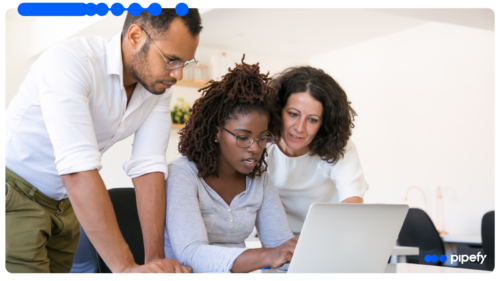 Equipe de negócio e TI analisando workflows inteligentes em um laptop no escritório