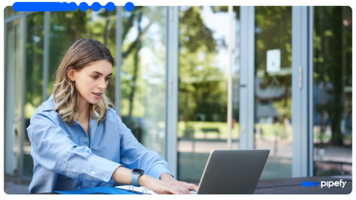Profissional trabalha em laptop em ambiente aberto, representando a gestão de processos com orquestração e automação inteligente