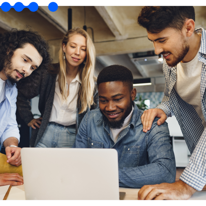 Equipe reunida em escritório moderno colaborando e olhando para um laptop, utilizando uma ferramenta de gestão de tarefas para organizar o trabalho