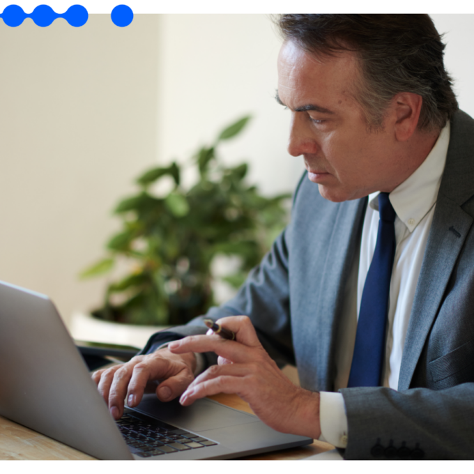 Senior finance professional in a suit working intently on a laptop to manage finance workflow automation at his desk