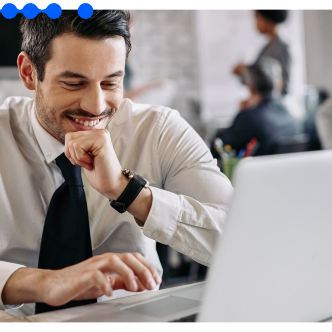Smiling male professional using a laptop to manage AI workflows in a modern office environment
