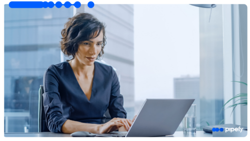 Executiva de cabelo curto trabalhando concentrada em um laptop num escritório moderno e bem iluminado, realizando a gestão de seguros