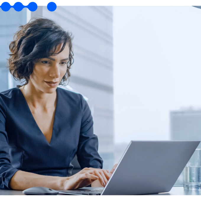 Executiva de cabelo curto trabalhando concentrada em um laptop num escritório moderno e bem iluminado, realizando a gestão de seguros