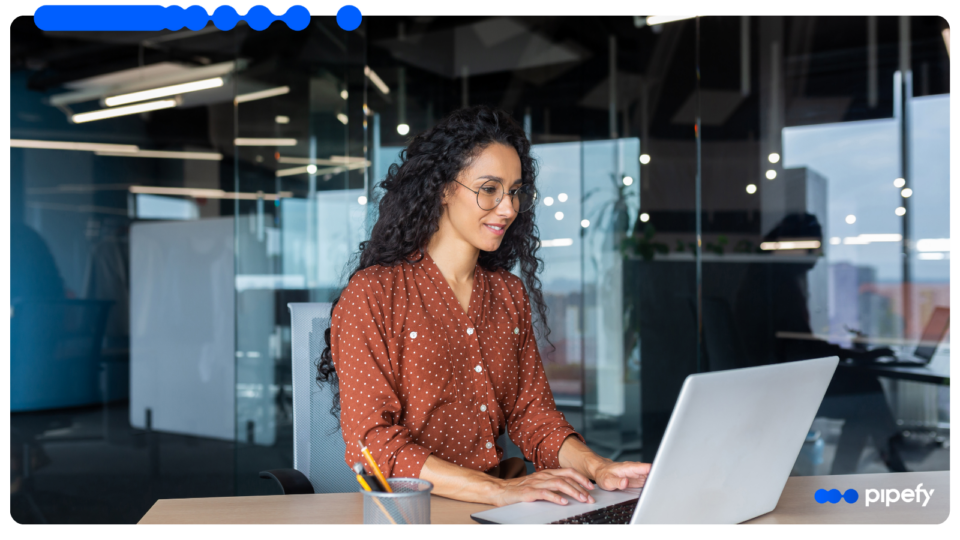 Profissional trabalha em laptop em escritório corporativo moderno, estruturando a orquestração com Inteligência Artificial