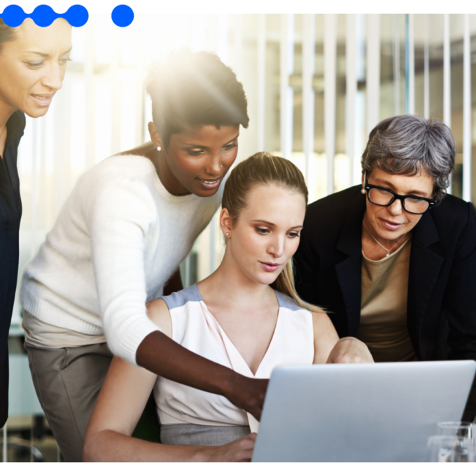 Equipe de vendas reunida em torno de um laptop analisa o pipeline, ilustrando como um CRM para B2B organiza o ciclo comercial