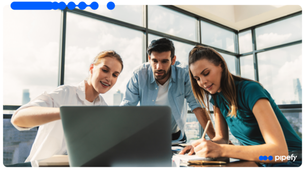 A team reviews data of credit workflow automation for B2B companies on a laptop in a modern office