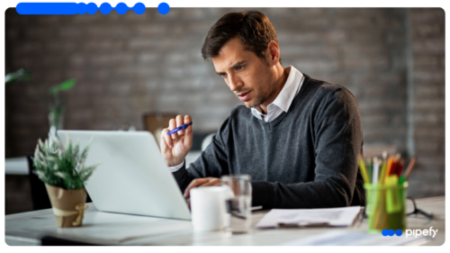 A focused IT leader studies his laptop at a desk, evaluating an enterprise systems integration that works on top of existing systems rather than replacing them