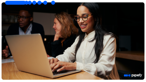 IT professionals work on laptops in a modern office, evaluating a legacy system integration approach that orchestrates systems without downtime