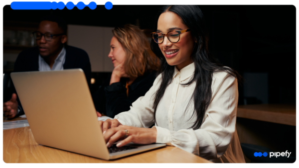 IT professionals work on laptops in a modern office, evaluating a legacy system integration approach that orchestrates systems without downtime