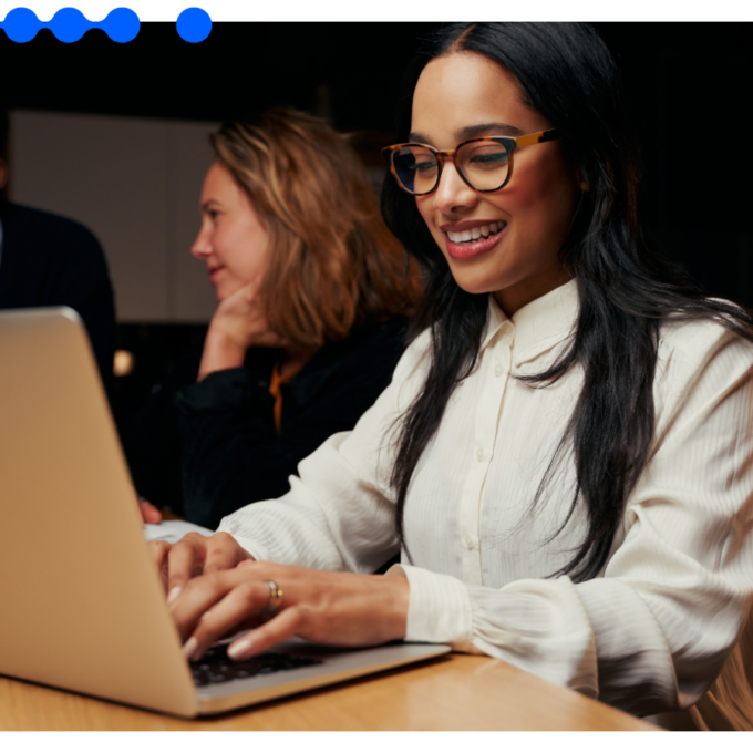 IT professionals work on laptops in a modern office, evaluating a legacy system integration approach that orchestrates systems without downtime