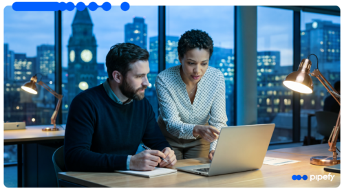 Two enterprise professionals reviewing Agentic AI for enterprise on a laptop in an office at night